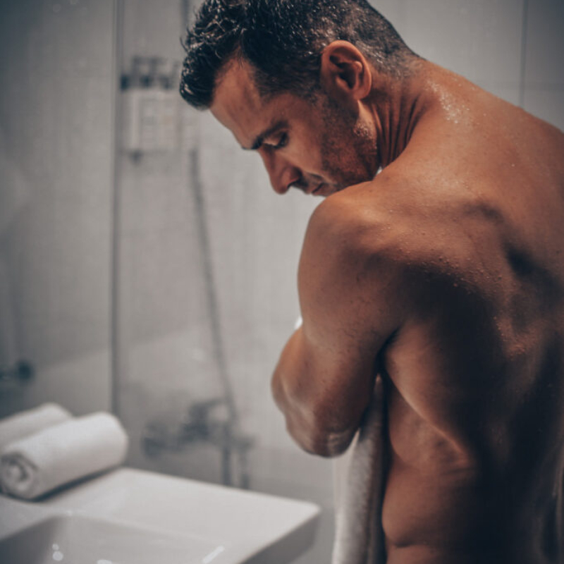 Muscular man drying off with a white towel in a modern bathroom. High-quality male photography by Photographer Slovakia.
