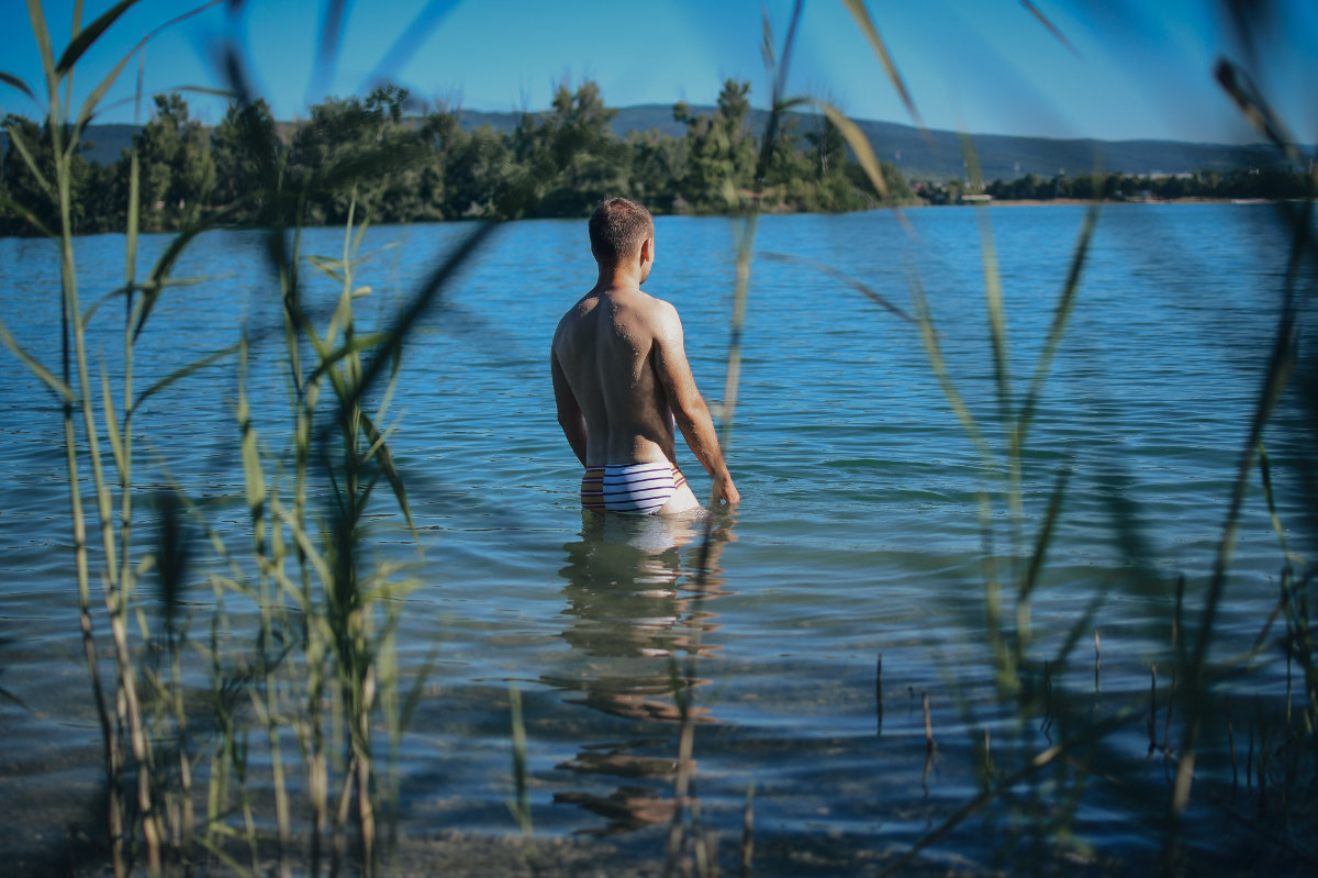Muscular man standing in a swimsuit in the lake. High-quality male photography by Photographer Slovakia.